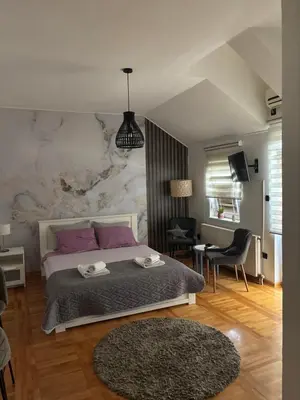 a bedroom with a large bed with a marble wall at Gaga Gold in Belgrade