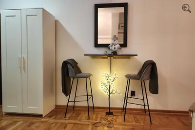 a room with two stools and a table with a plant at Gaga Gold in Belgrade