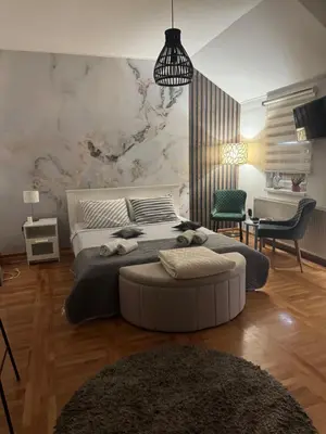 a bedroom with a large bed and a pendant light at Gaga Gold in Belgrade