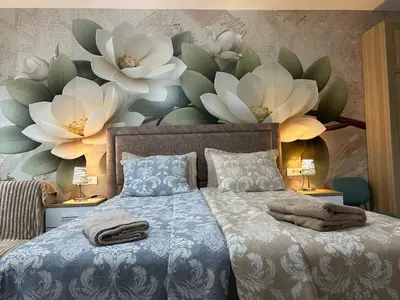 a bedroom with a bed with flowers on the wall at Studio Lotos in Belgrade