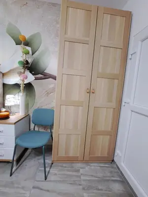 a room with a wooden door and a blue chair at Studio Lotos in Belgrade