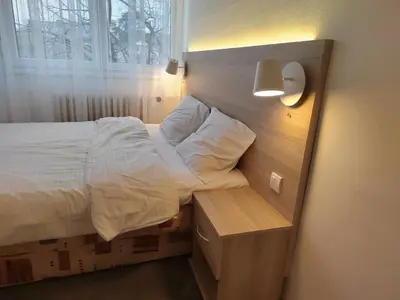 a bedroom with a bed with a wooden head board at Lira Beo in Vračar (historical)