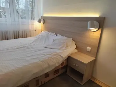 a bedroom with a large bed with a nightstand and a window at Lira Beo in Vračar (historical)
