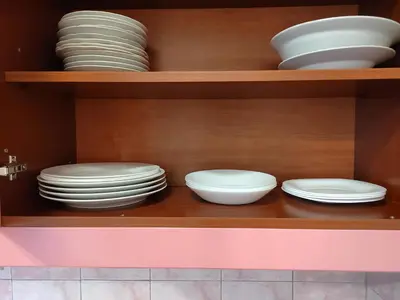 a cabinet filled with white plates and bowls at Lira Beo in Vračar (historical)