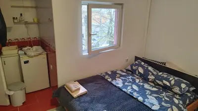 a small bedroom with a bed and a window at Small Apartment FREE TRANSPORTATION FROM THE AIRPORT TO THE APARTMENT in Belgrade