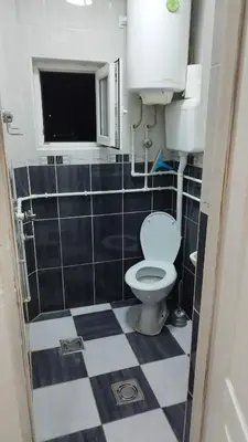 a bathroom with a toilet and a tiled floor at Small Apartment FREE TRANSPORTATION FROM THE AIRPORT TO THE APARTMENT in Belgrade