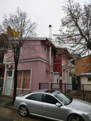 a silver car parked in front of a pink house at Small Apartment FREE TRANSPORTATION FROM THE AIRPORT TO THE APARTMENT in Belgrade