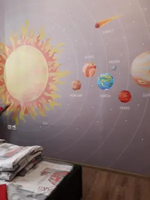 a mural of the solar system on a bedroom wall at STUDIO Eva in Sajmište