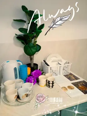 a table with cups and plates and a plant at STUDIO Eva in Sajmište