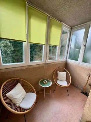 two chairs and a table in a room with windows at Apartman - Hani in Rakovica