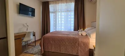 a bedroom with a bed and a desk and a window at Premium Studio Apartment - Belgrade Waterfront in Sajmište