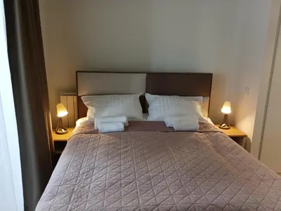 a bedroom with a large bed with two lamps at Premium Studio Apartment - Belgrade Waterfront in Sajmište