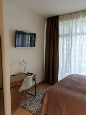 a bedroom with a bed and a desk and a television at Premium Studio Apartment - Belgrade Waterfront in Sajmište