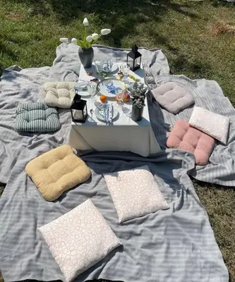 a picnic blanket with a table with a plate of food at Vikendica Fruskogorski kutak in Krušedol