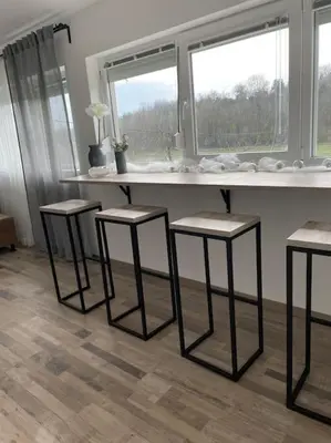 a kitchen with three stools and a counter with three windows at Vikendica Fruskogorski kutak in Krušedol