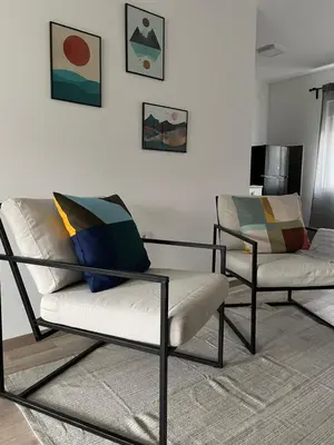 a living room with two chairs and a wall at Vikendica Fruskogorski kutak in Krušedol