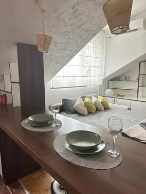 a table with two plates and wine glasses on it at TRIANGLE CITY Apartment 1 in Belgrade