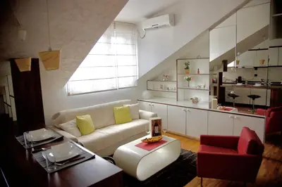 a living room with a white couch and a window at TRIANGLE CITY Apartment 1 in Belgrade