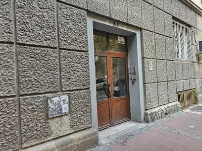 a building with a wooden door on the side of it at The Traveling Theater in Belgrade