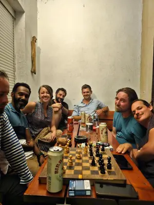 a group of people sitting around a chess board at The Traveling Theater in Belgrade