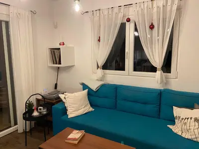 a blue couch in a living room with a window at Kućica in Velika Remeta