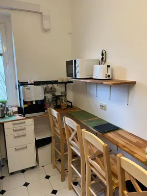 a kitchen with a table with chairs and a microwave at Cabbage Hostel in Belgrade
