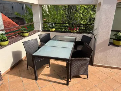 a glass table and chairs on a patio at Cabbage Hostel in Belgrade