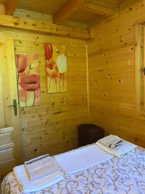 a room with a bed in a wooden cabin at Brvnara oaza mira - Devojacki bunar in Alibunar
