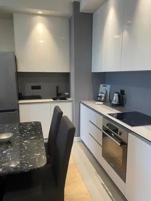 a kitchen with white cabinets and a table and a stove at ForS Belgrade Waterfront in Belgrade