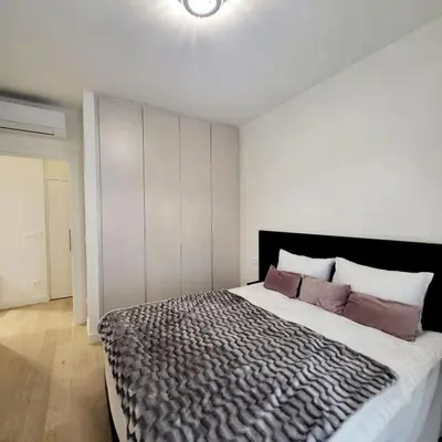 a bedroom with a large bed with purple pillows at ForS Belgrade Waterfront in Belgrade