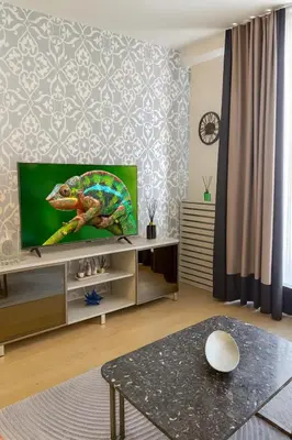 a living room with a tv with a lizard on the screen at ForS Belgrade Waterfront in Belgrade