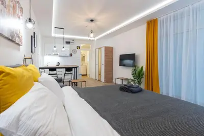 a bedroom with a white bed and a living room at Siva in Fontana