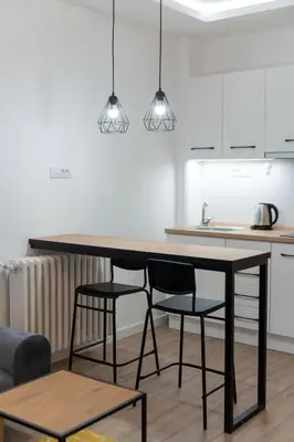 a kitchen with a black table and two chairs at Siva in Fontana