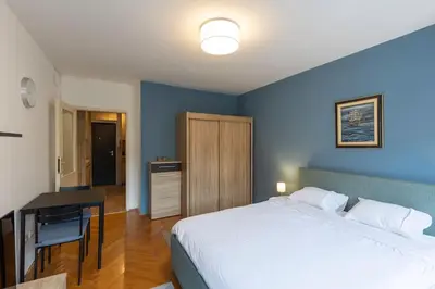a bedroom with a large bed and a table and a desk at Belgrade Center Apartment in Belgrade