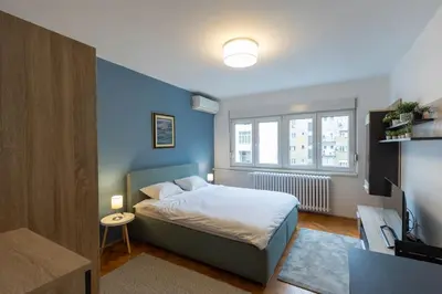 a bedroom with a bed with a blue wall at Belgrade Center Apartment in Belgrade