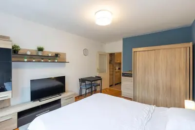 a bedroom with a white bed and a flat screen tv at Belgrade Center Apartment in Belgrade