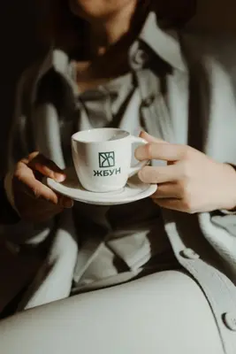 a woman is holding a coffee cup on aucer at Studio Žbun - Kuća na Avali in Pavi°evac