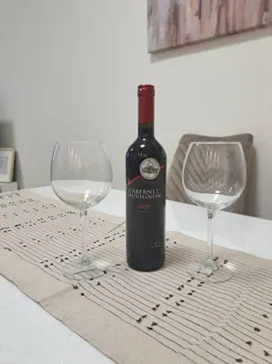a bottle of wine and two wine glasses on a table at MarijaN Belgrade Waterfront in Sajmište