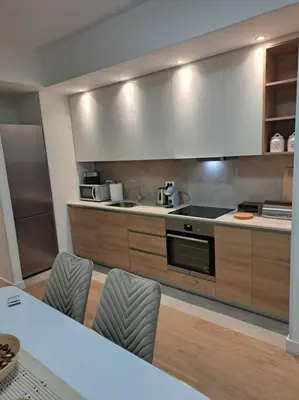 a kitchen with a stove and some chairs in it at MarijaN Belgrade Waterfront in Sajmište