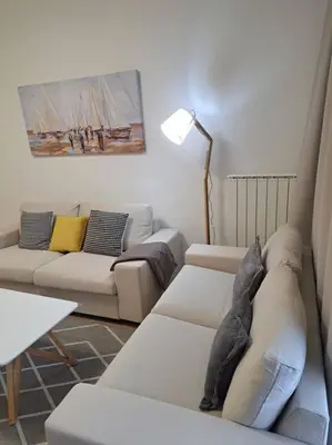 a living room with a white couch and a table at MarijaN Belgrade Waterfront in Sajmište