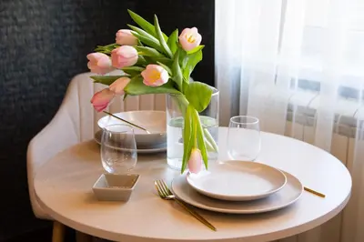 a table with plates and a vase of flowers on it at Square 6 in Belgrade