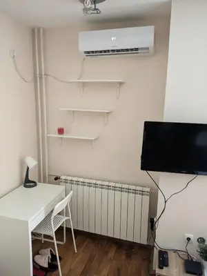 a room with a desk and a tv and a radiator at NMD Apartments in Zvezdara