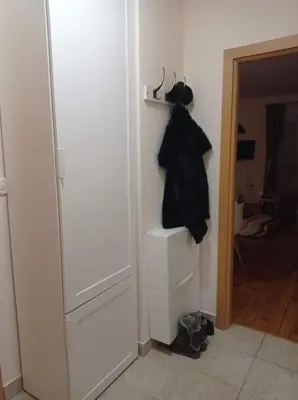 a room with a closet with two drawers and a black coat at NMD Apartments in Zvezdara