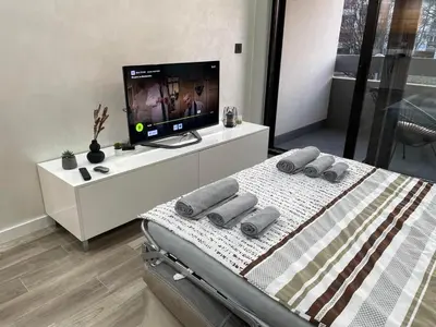 a bedroom with a bed with a television on a white cabinet at Alisa Novi Beograd in Bežanija
