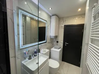 a bathroom with a toilet and a sink and a mirror at Alisa Novi Beograd in Bežanija