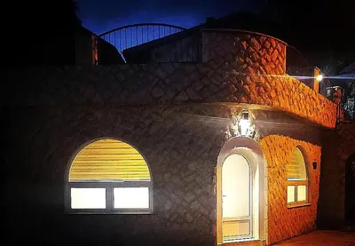 a building with two arched windows at night at Apartman Kedar in Arandjelovac