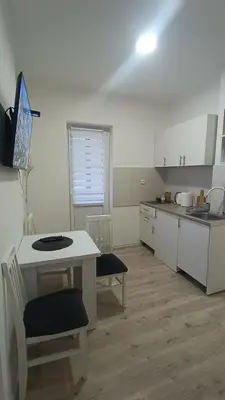 a kitchen with a white table and a table and chairs at Gepratova Apartment in Belgrade