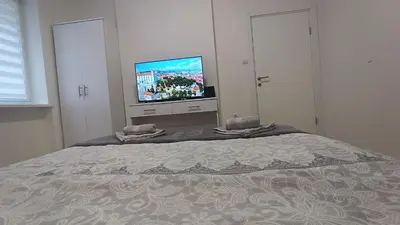 a bedroom with a bed with a flat screen tv at Gepratova Apartment in Belgrade