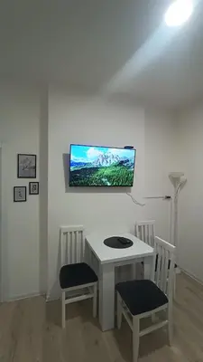 a white table with two chairs and a tv on a wall at Gepratova Apartment in Belgrade