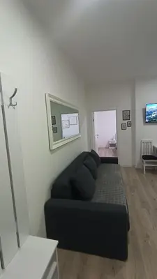 a living room with a black couch in a room at Gepratova Apartment in Belgrade